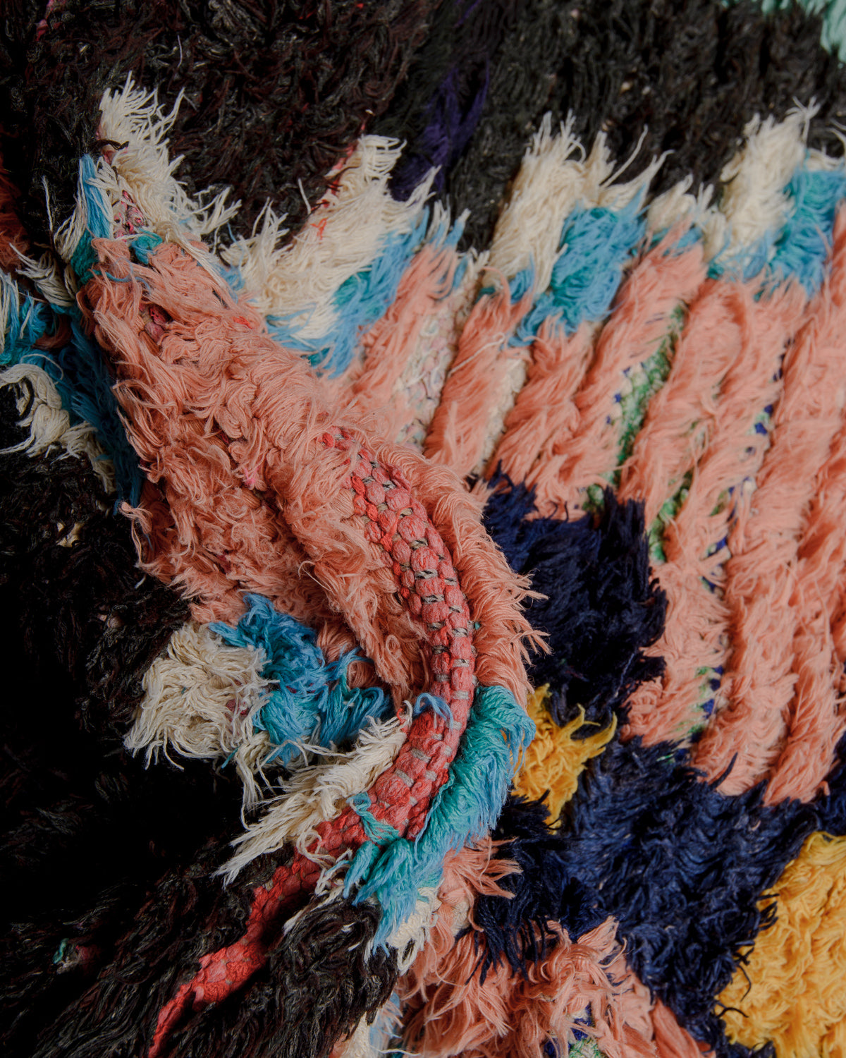 Close up of boucherouite rug with colourful cotton and fabric remnants.