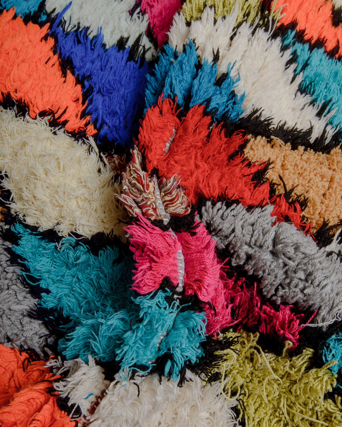 Close up of boucherouite rug with colourful cotton and fabric remnants.
