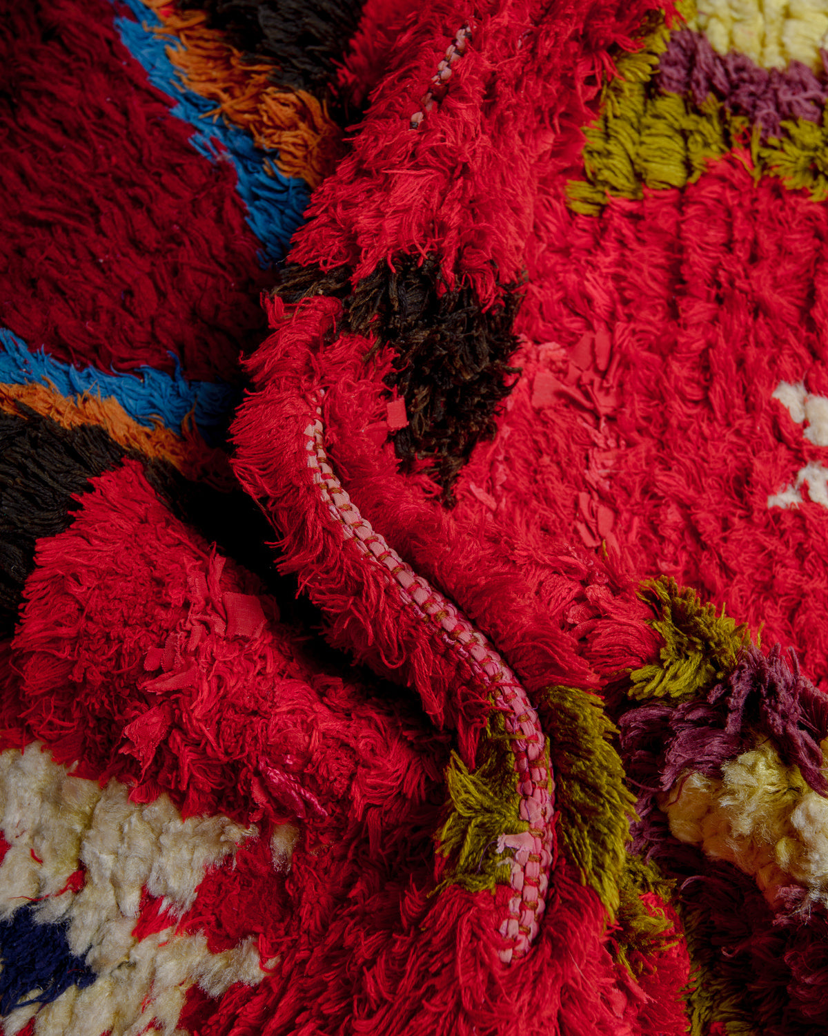Close up of boucherouite rug with colourful cotton and fabric remnants.