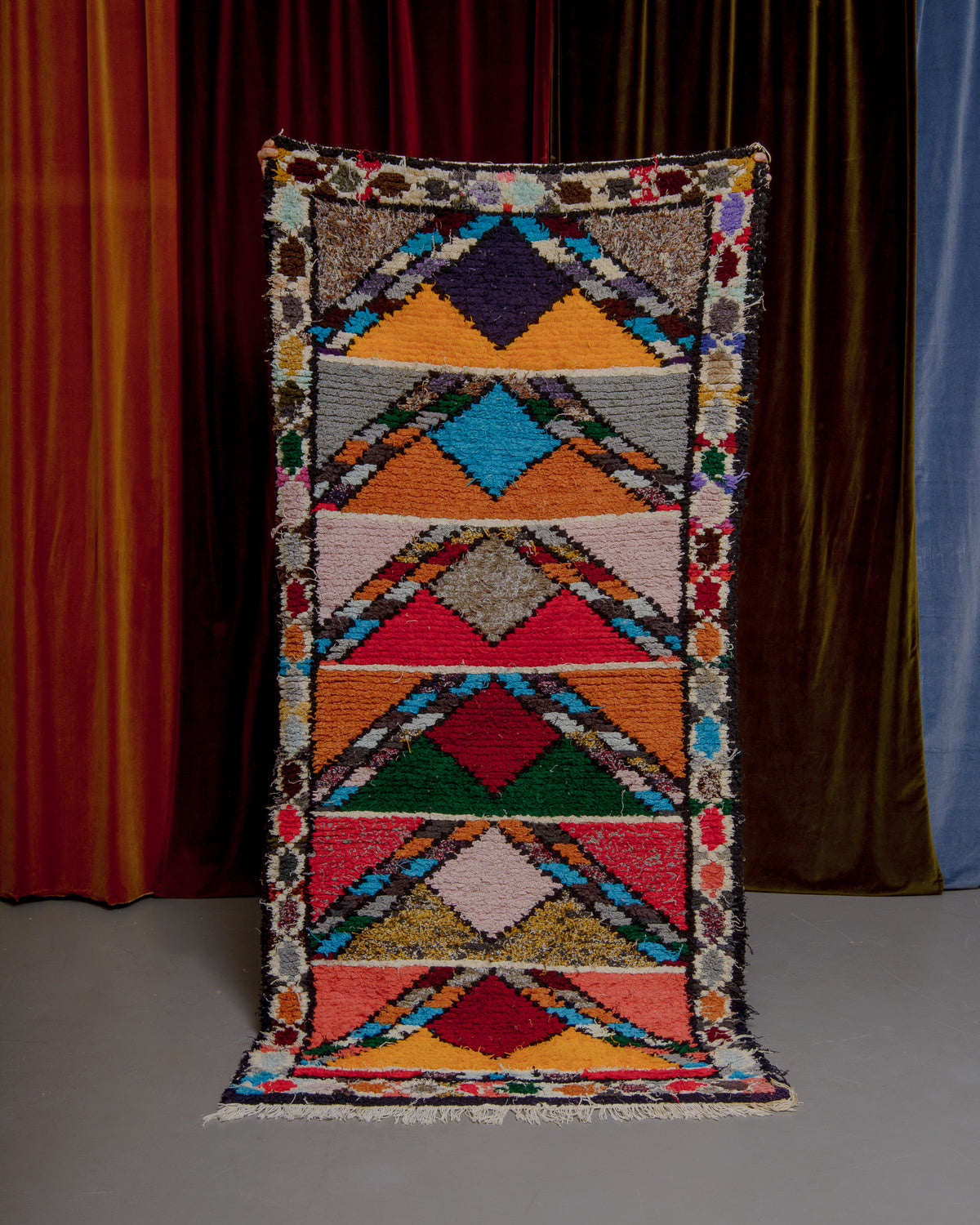 Boucherouite Runner held up in front of curtains.