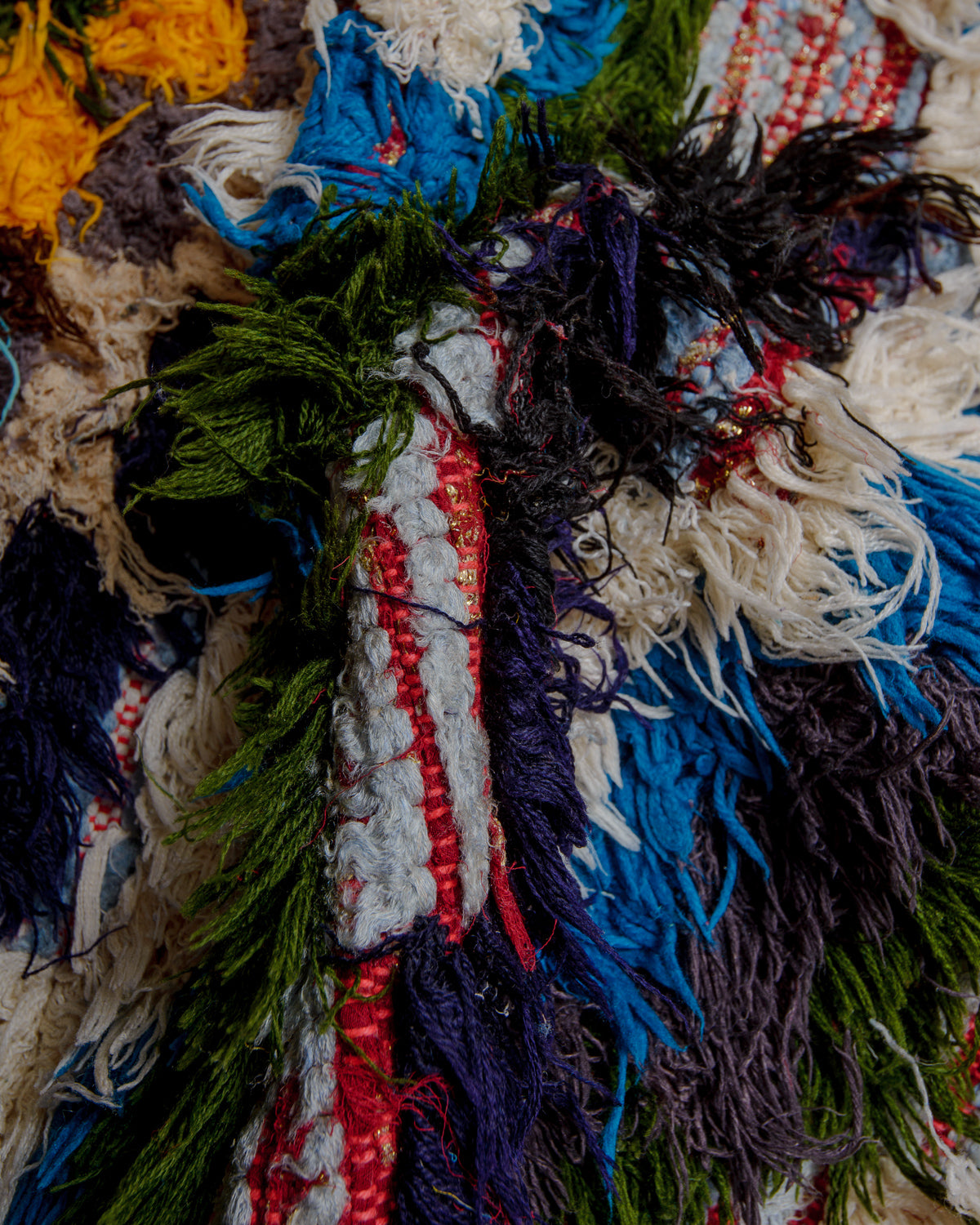 Close up of boucherouite rug with colourful cotton and fabric remnants.