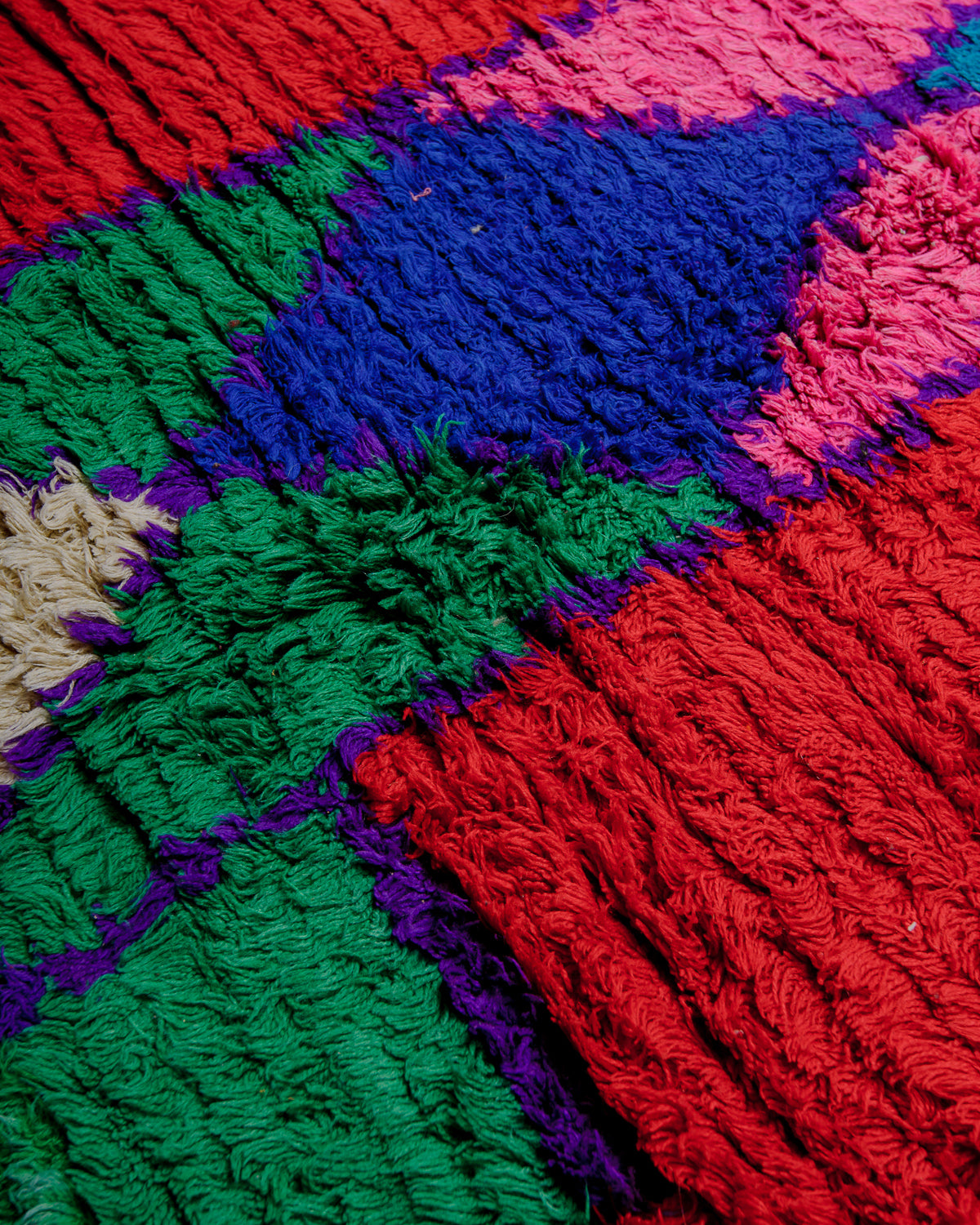 Close up of boucherouite rug with textured cotton and fabric remnants.