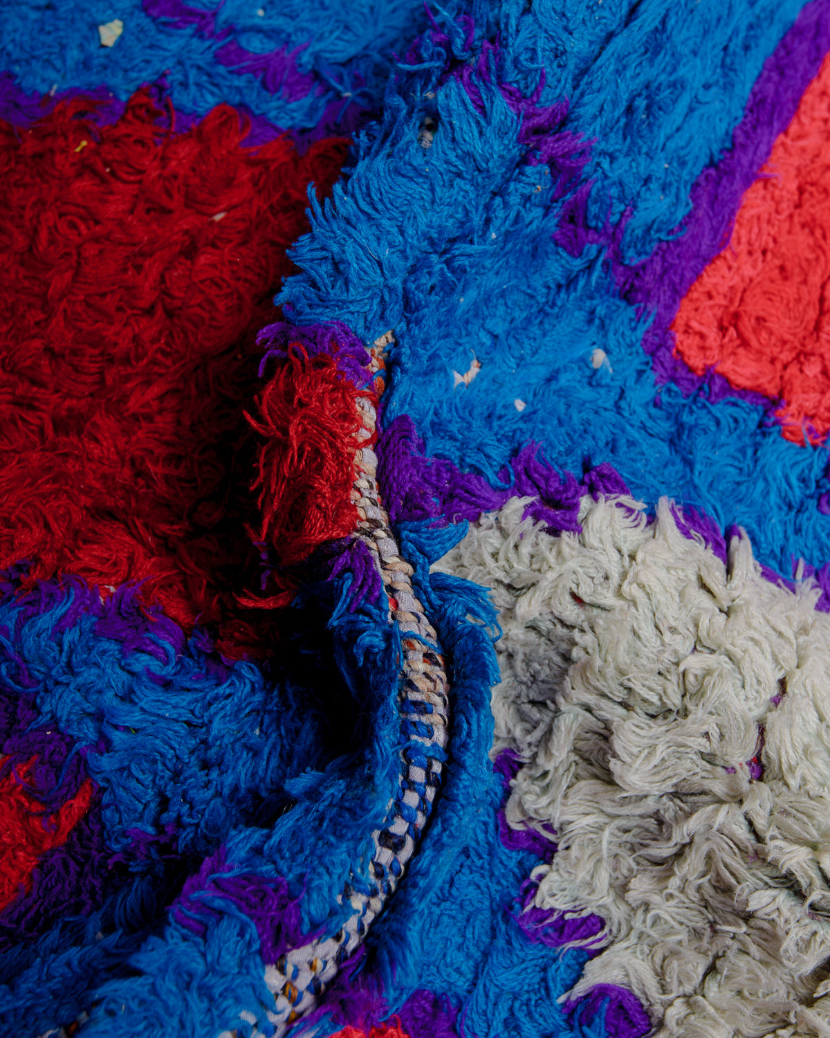Close up of boucherouite rug with textured cotton and fabric remnants.