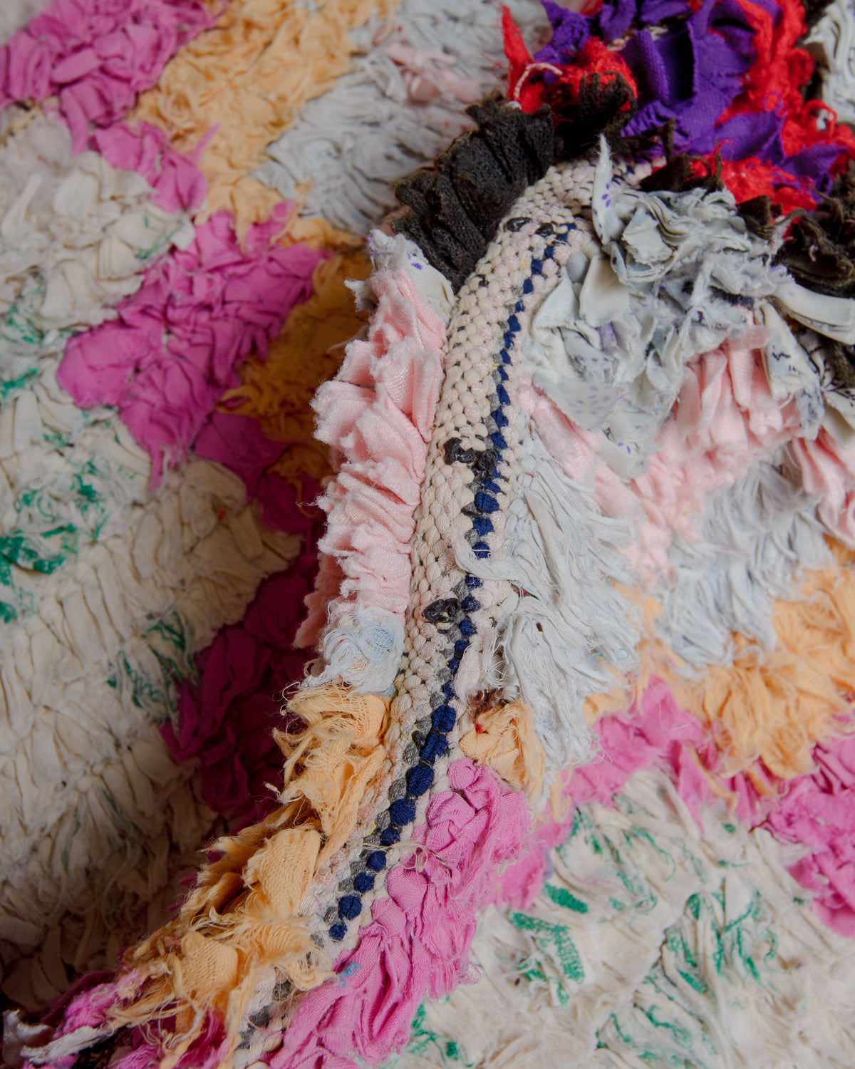 Close up of boucherouite rug with colourful cotton and fabric remnants.