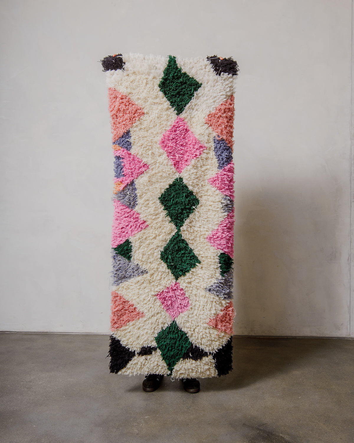 Textured rug with geometric pattern on a plain background.