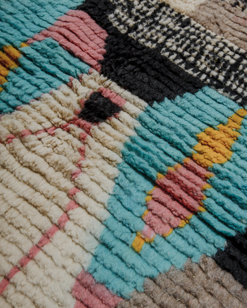 Surface of vintage boujaad rug showing depth of pile and cream, brown, pink and turquoise wool.