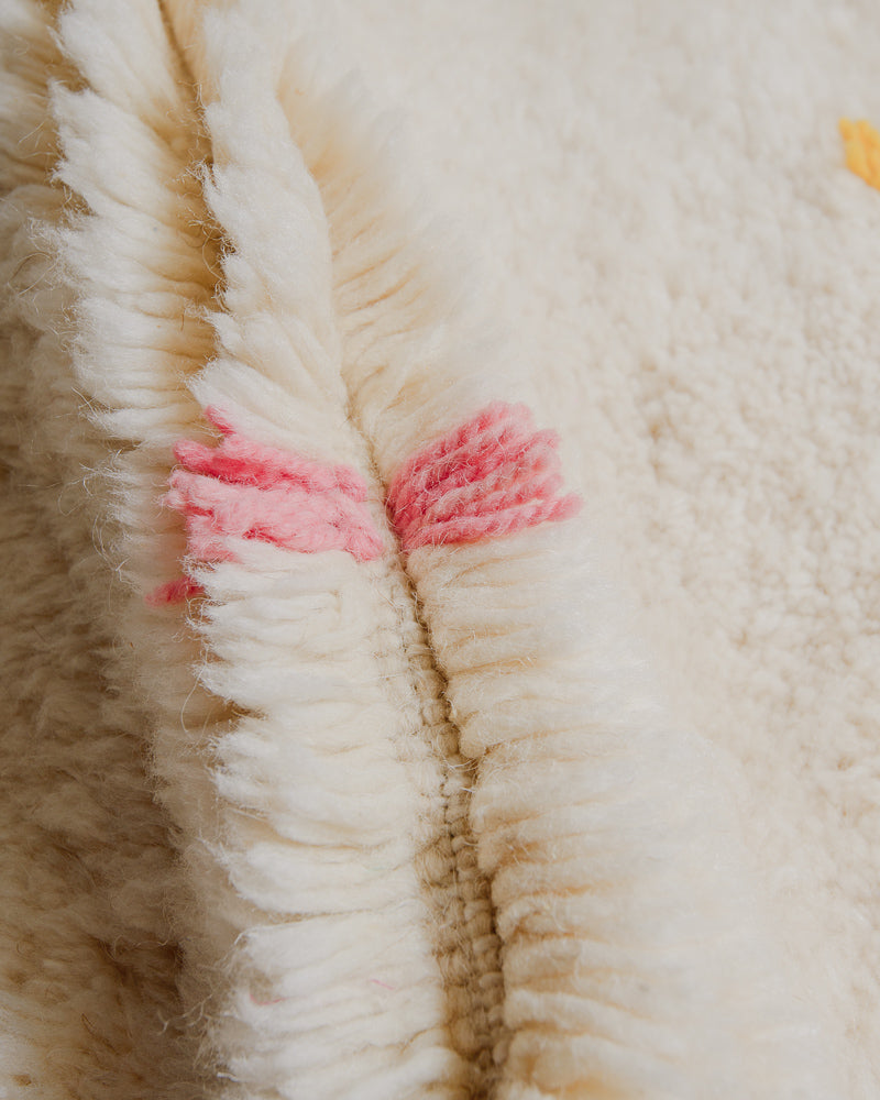 Close up of Berberlin Finest rug showing fluffy pile made of cream wool and pink wool detail.
