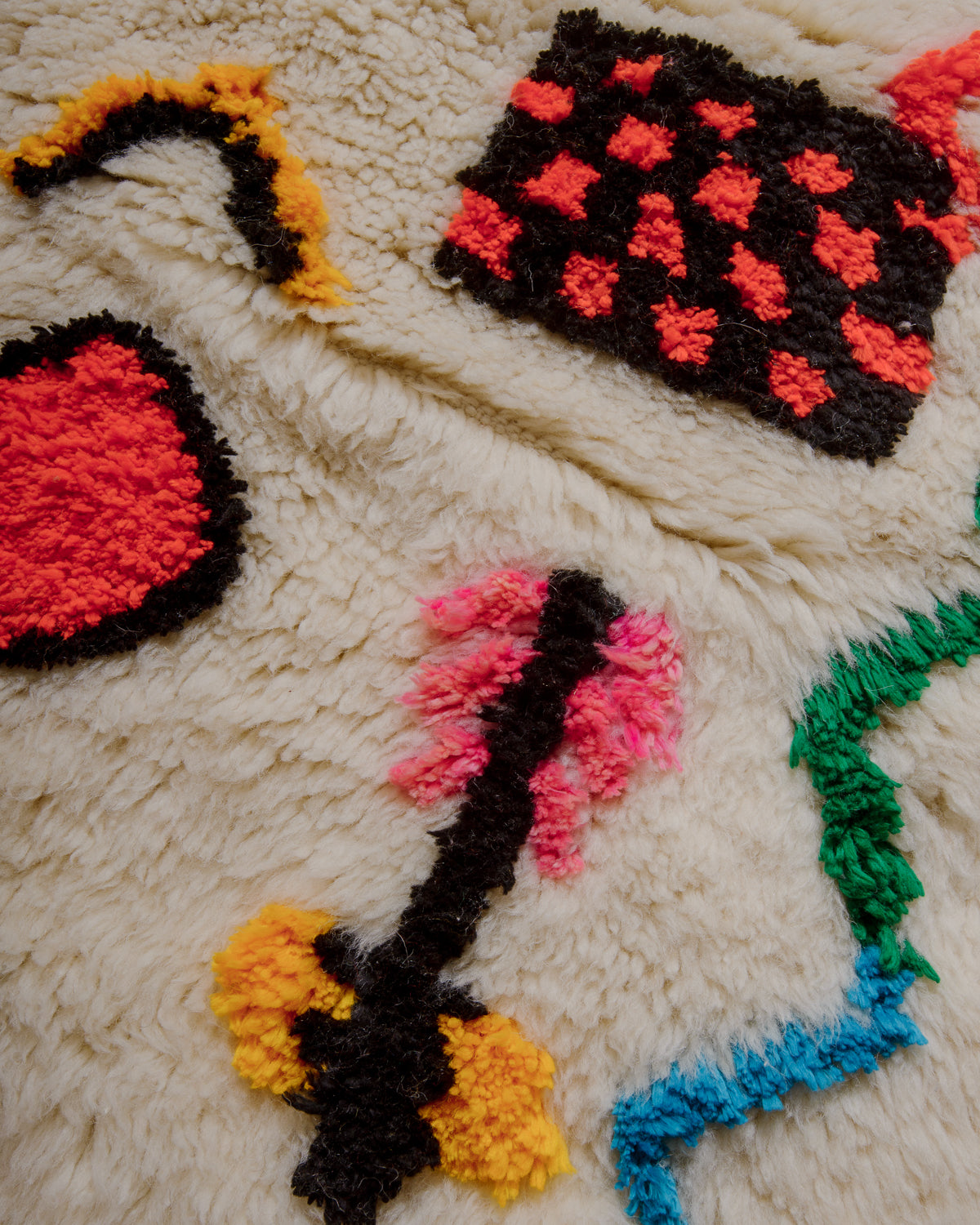 Surface of cream rug with colourful elements in fluffy cotton.