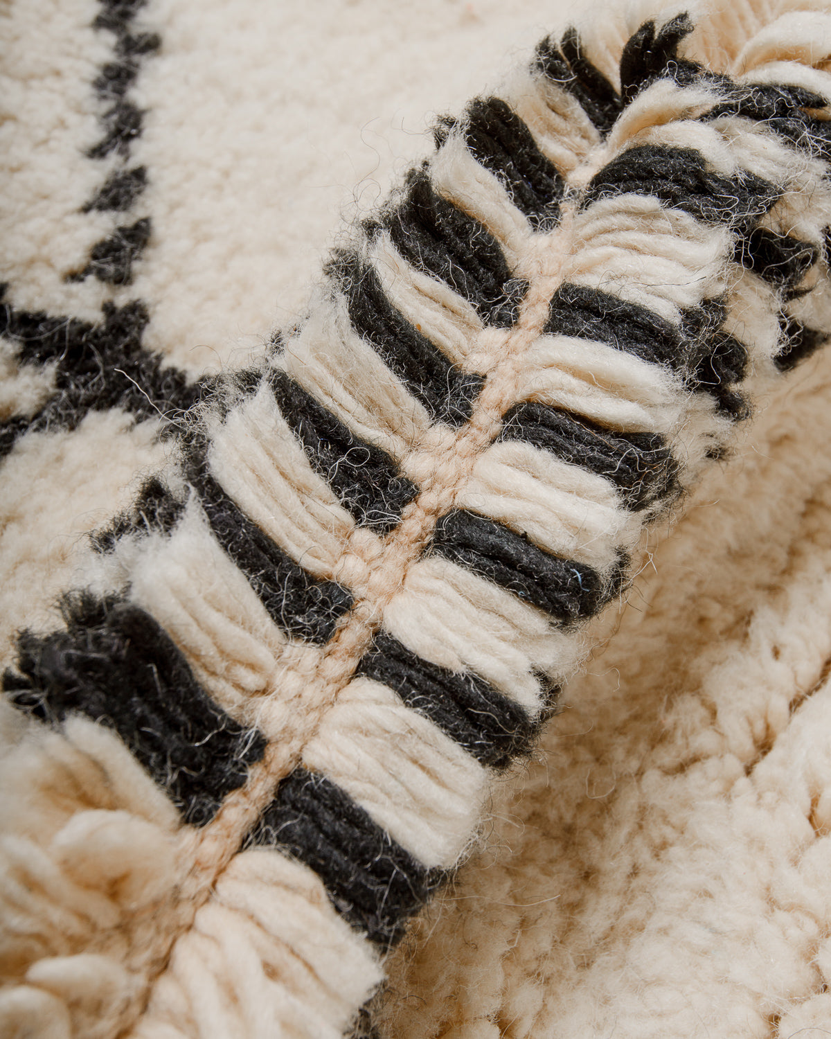 Close-up of a textured rug with black and cream pattern