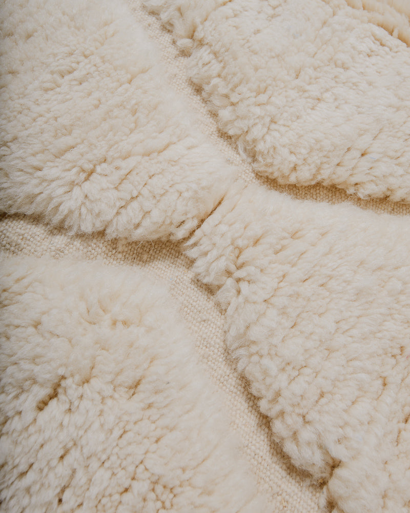 Close-up of a textured wool rug with a diamond pattern