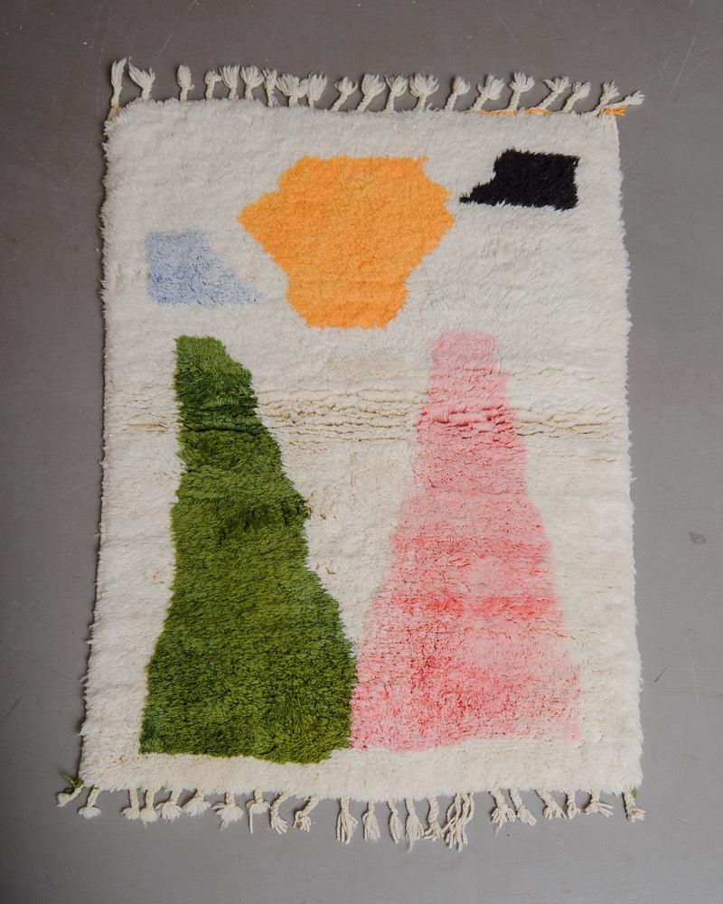 wool rug in cream with colour blocked on grey floor.