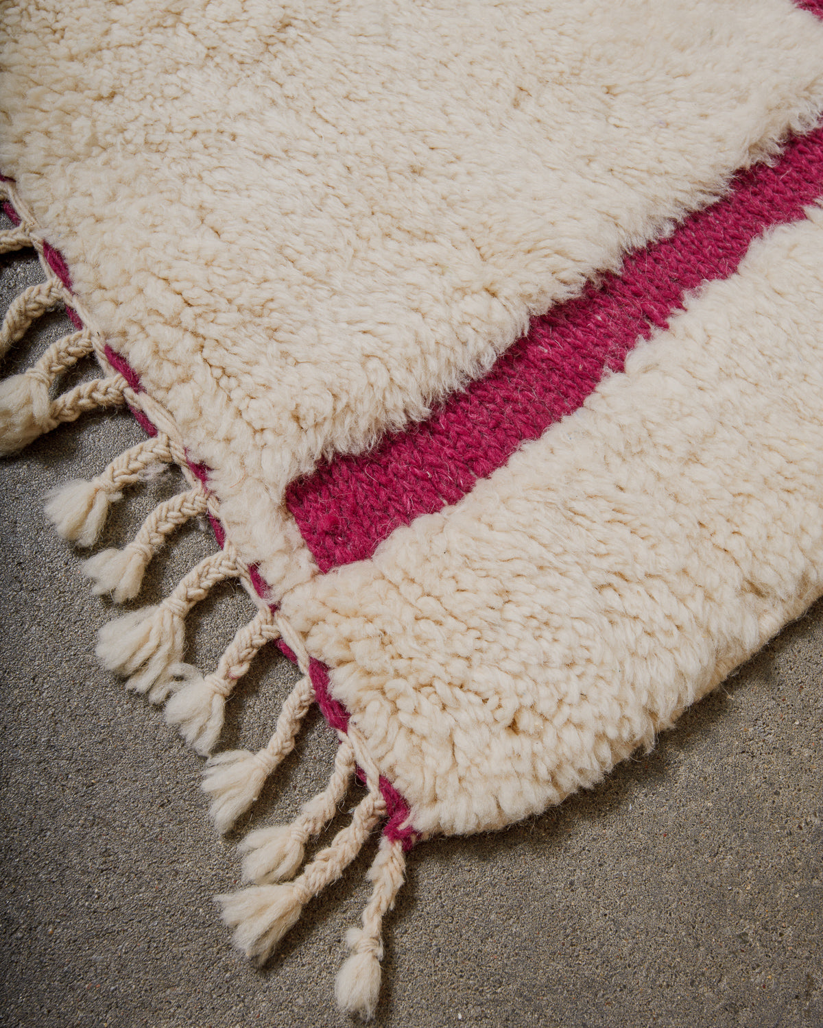 Close-up of a textured wool rug on a gray surface