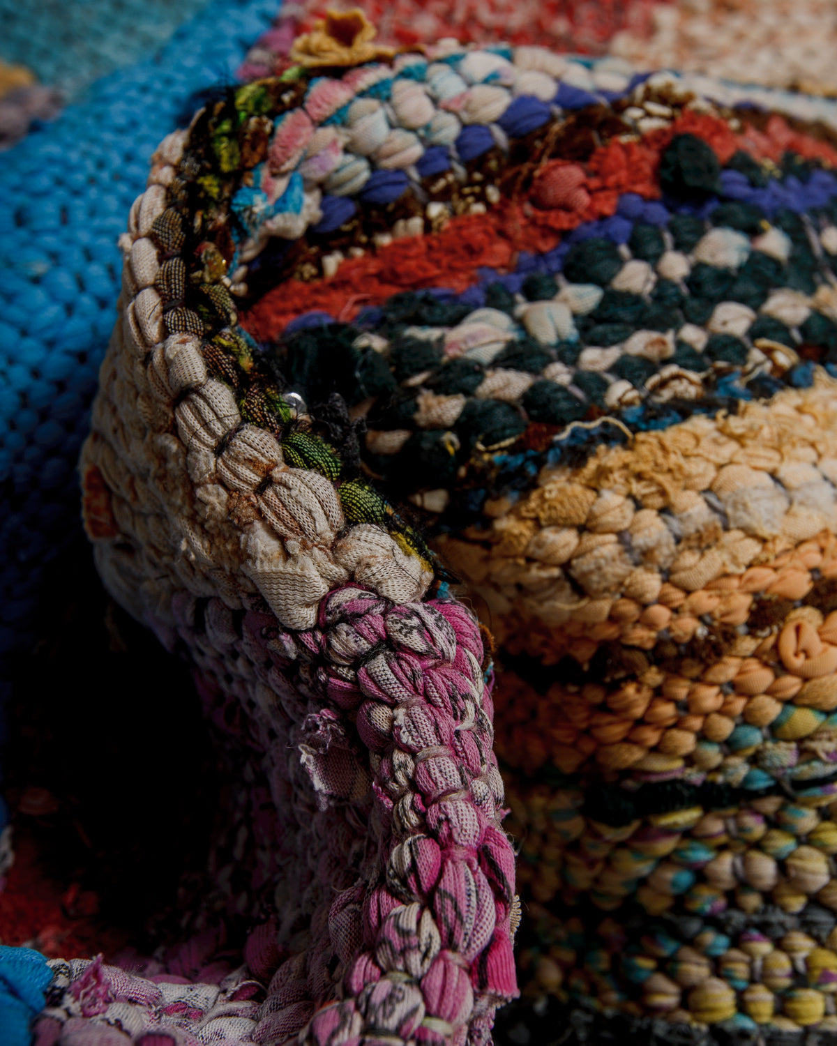 Close up of woven boucherouite rug with recycled cloth remnants in various colours and patterns.