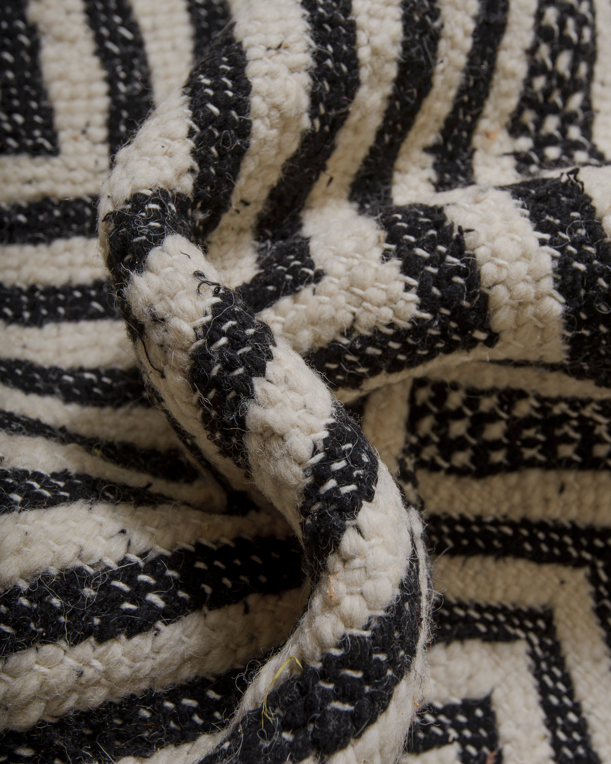Close-up of a textured black and white fabric with geometric pattern.