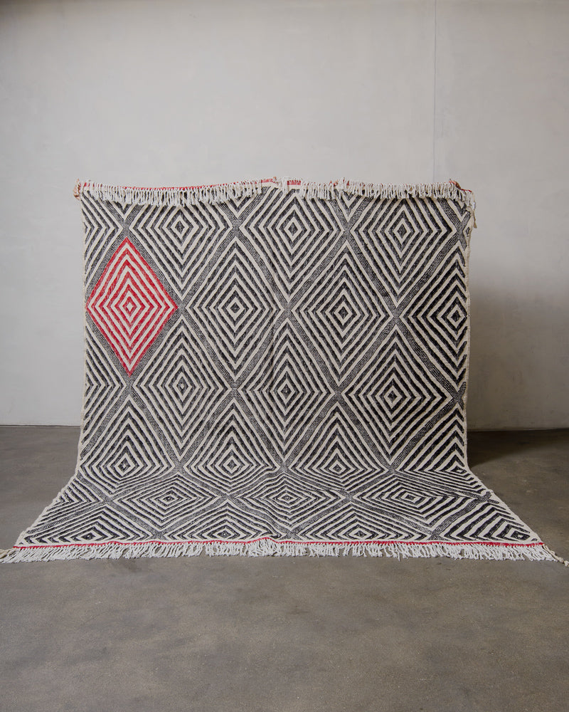 Berberlin Kelim rug with geometric pattern on a plain background.