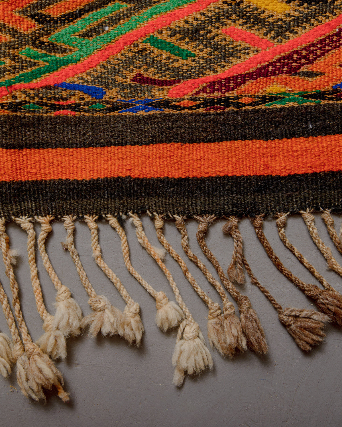 Close up of different coloured tassels, some cream, some brown.