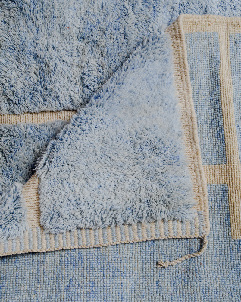 Folded over corner of mrirt rug showing the back of the rug and the density of knots.