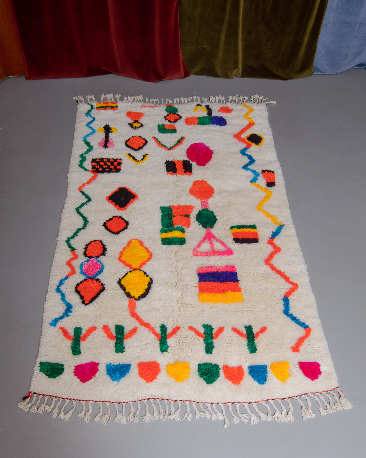 Berberlin Finest rug with a heavy cream pile and colourful design in cotton on a grey floor.