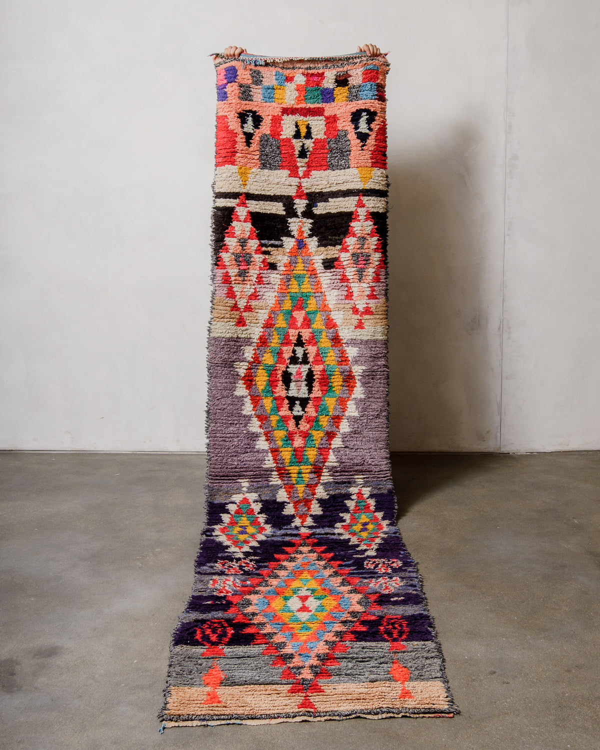 Colourful patterned rug on a plain floor with a neutral wall background