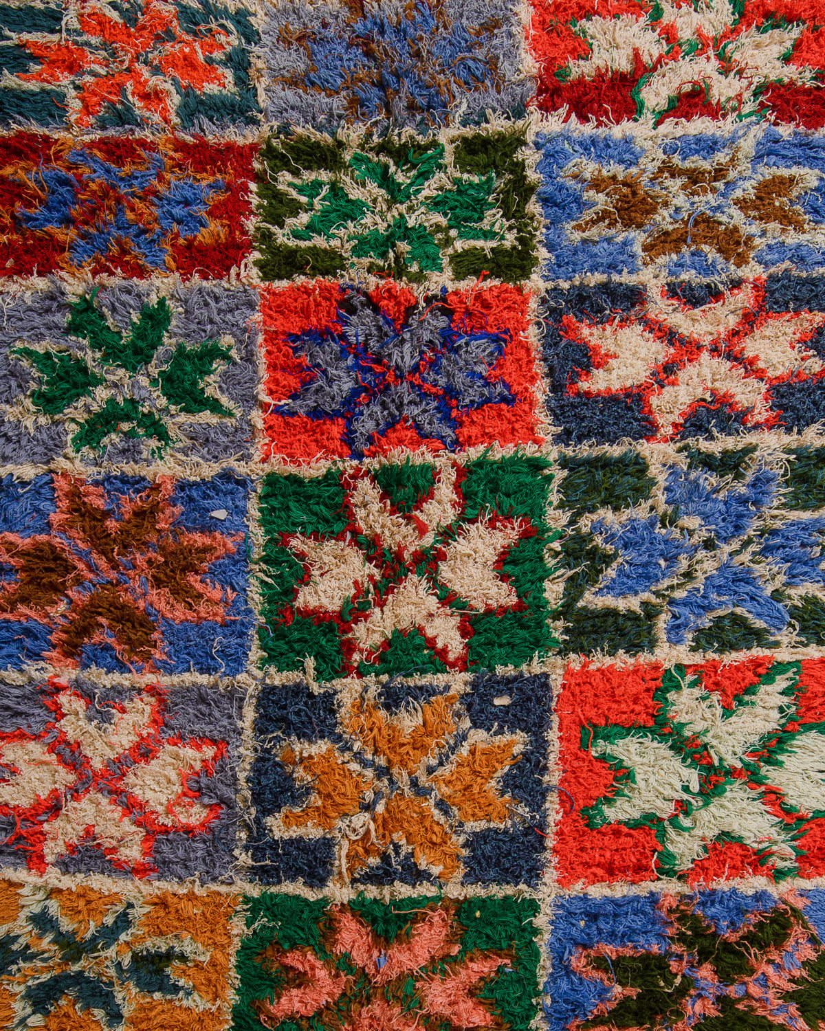 Close-up of a colourful patchwork rug with geometric patterns.