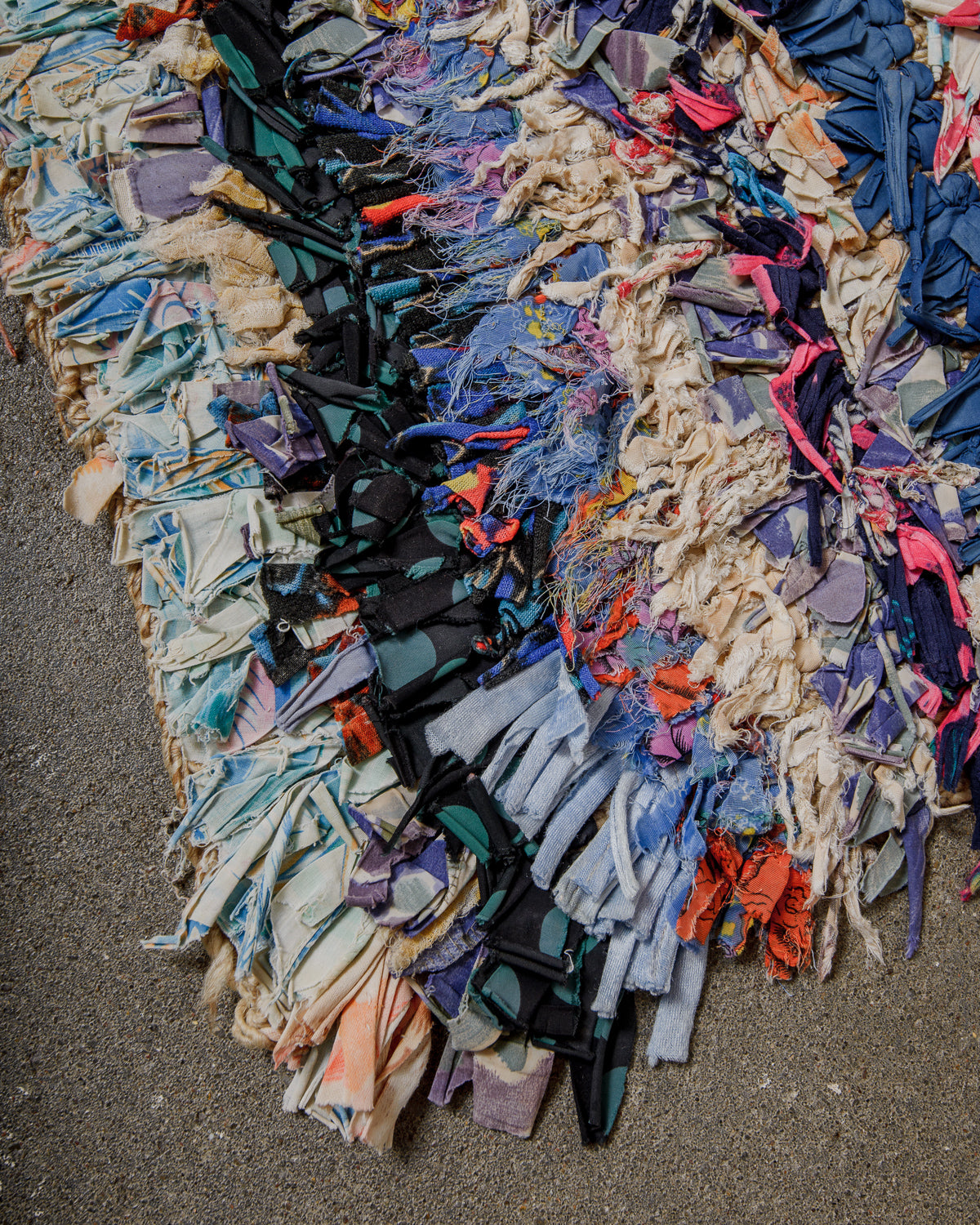 Multicolored fabric rug on a concrete floor