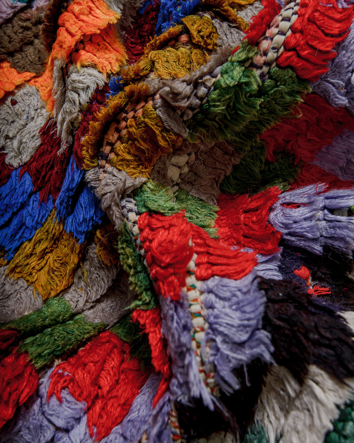 Close-up of a colourful textured fabric rug with various colours.