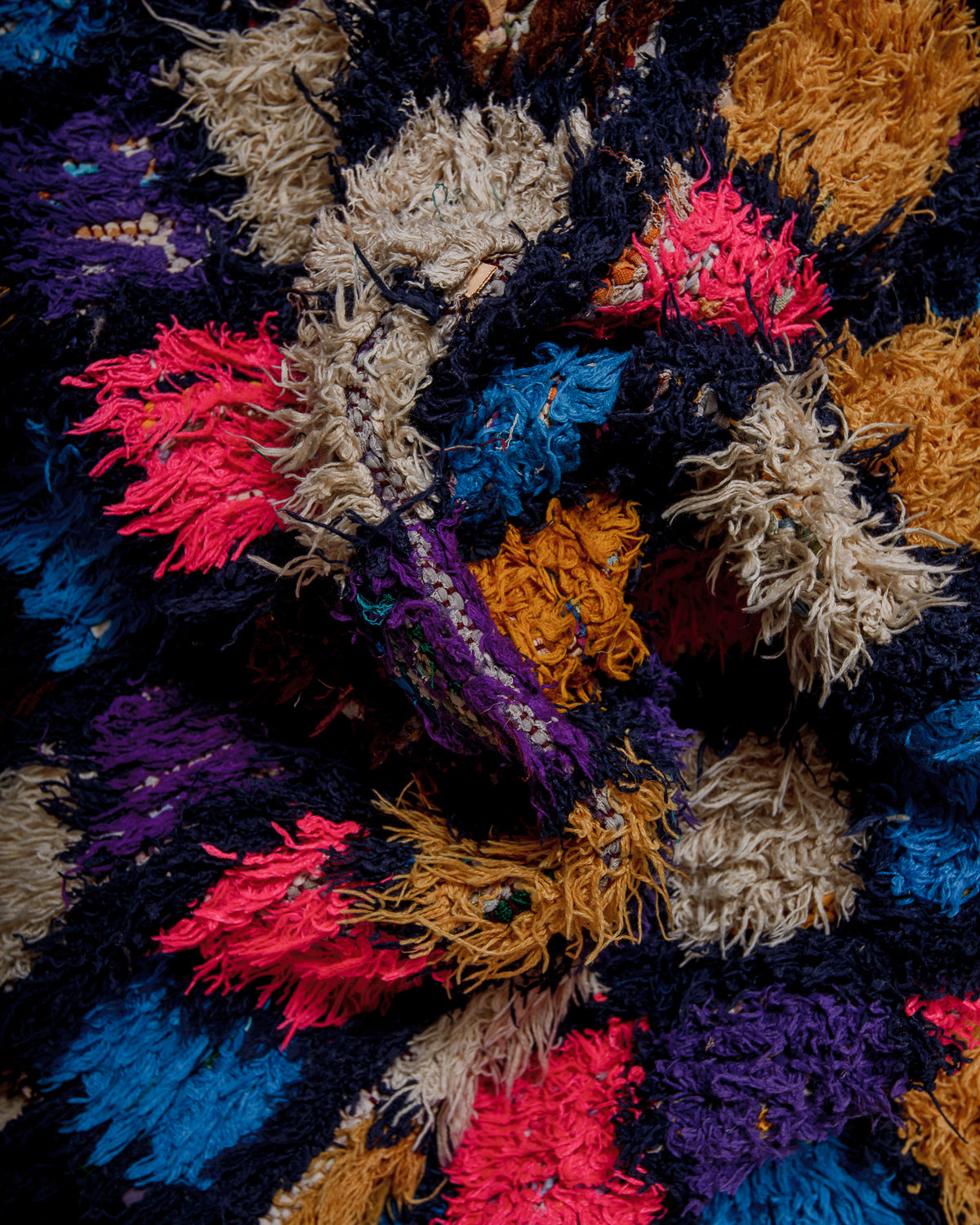 Close-up of a textured fabric rug with various colours.