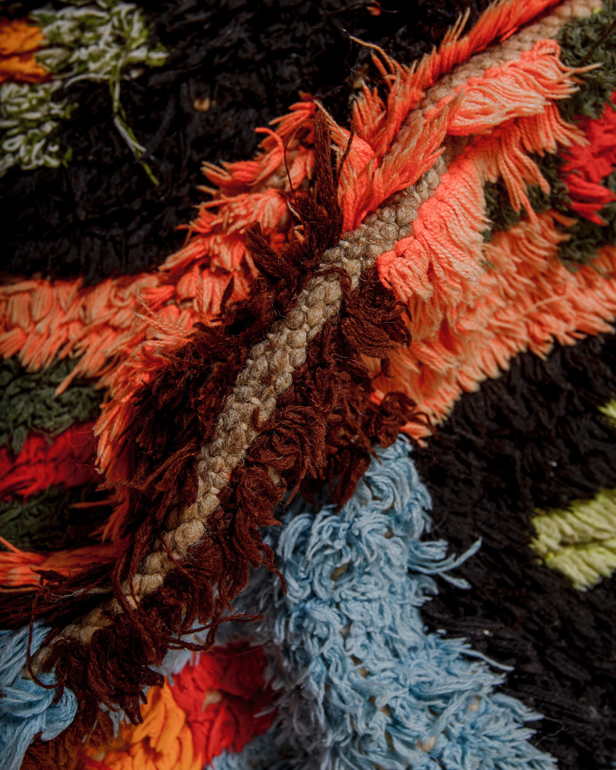 Close-up of a textured fabric rug with brown wool base.