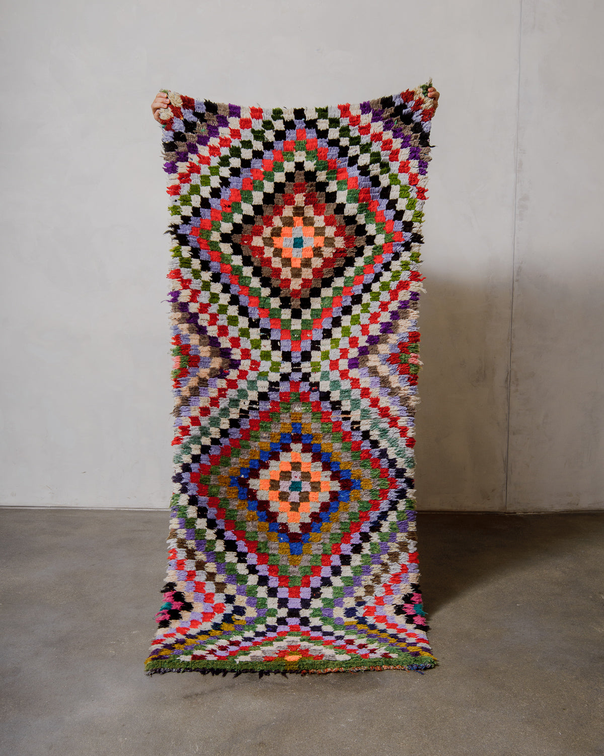 Multicoloured geometric patterned rug on a plain background