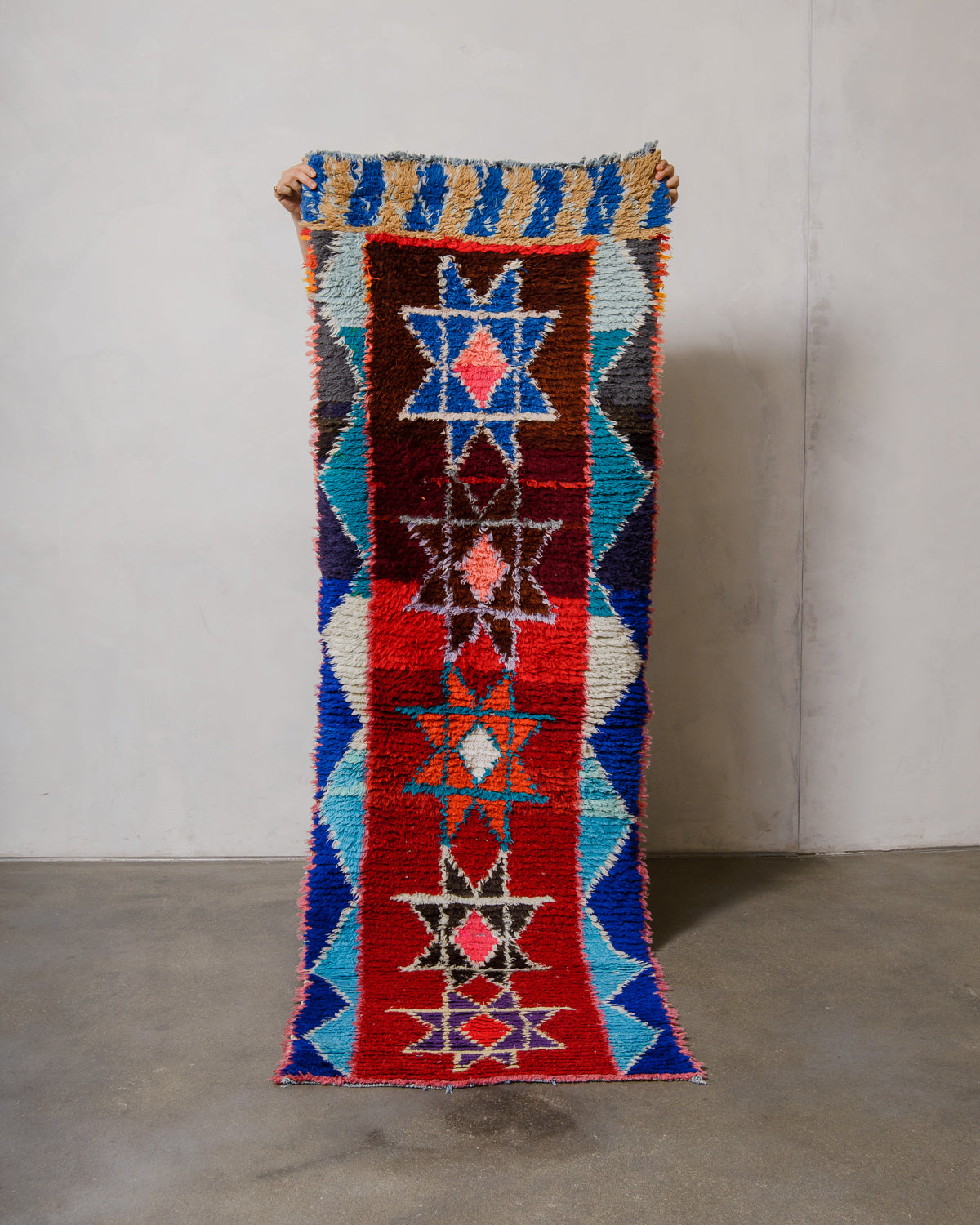 Colourful woven rug with geometric patterns on a plain background