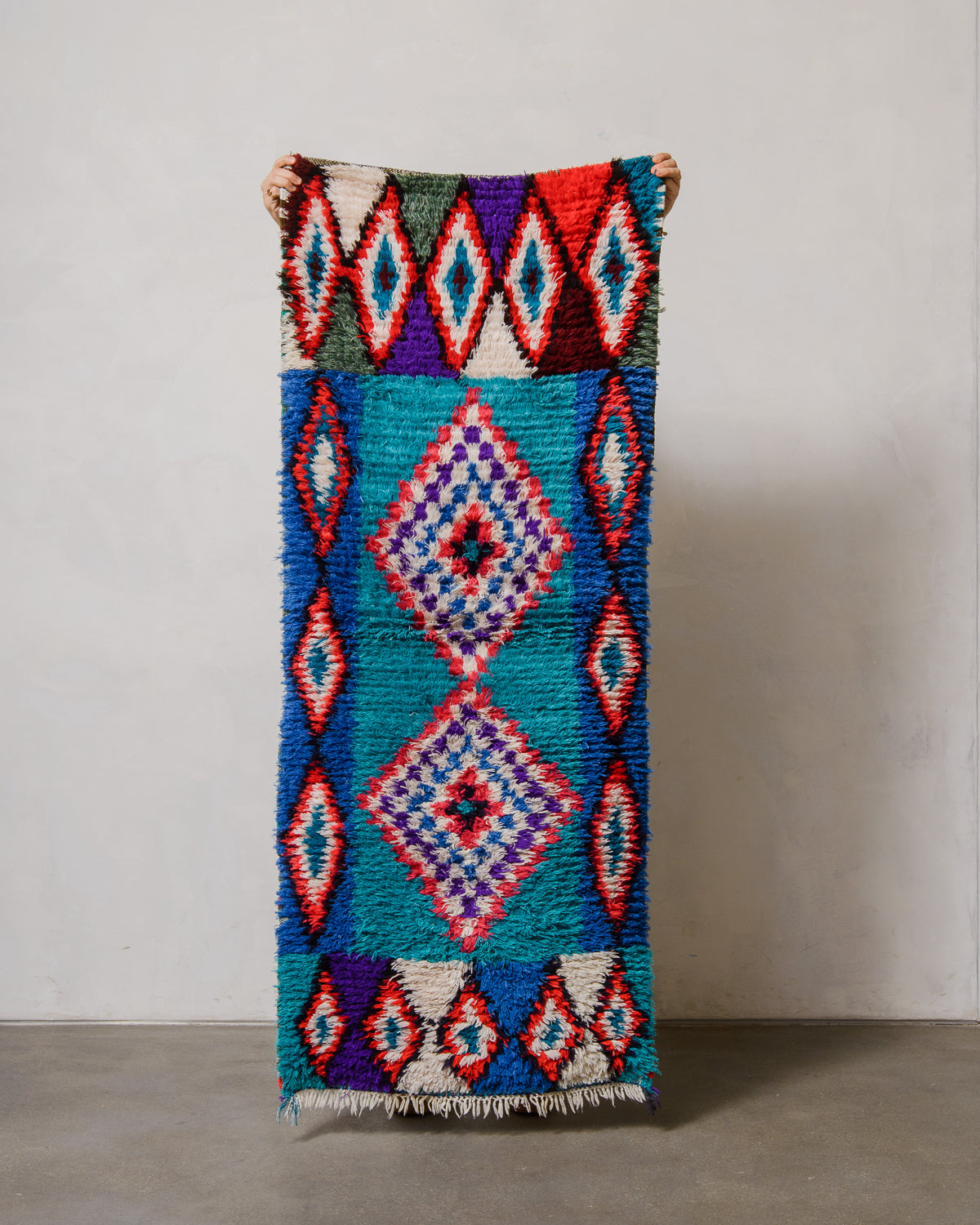 Colorful woven rug with geometric patterns on a plain background