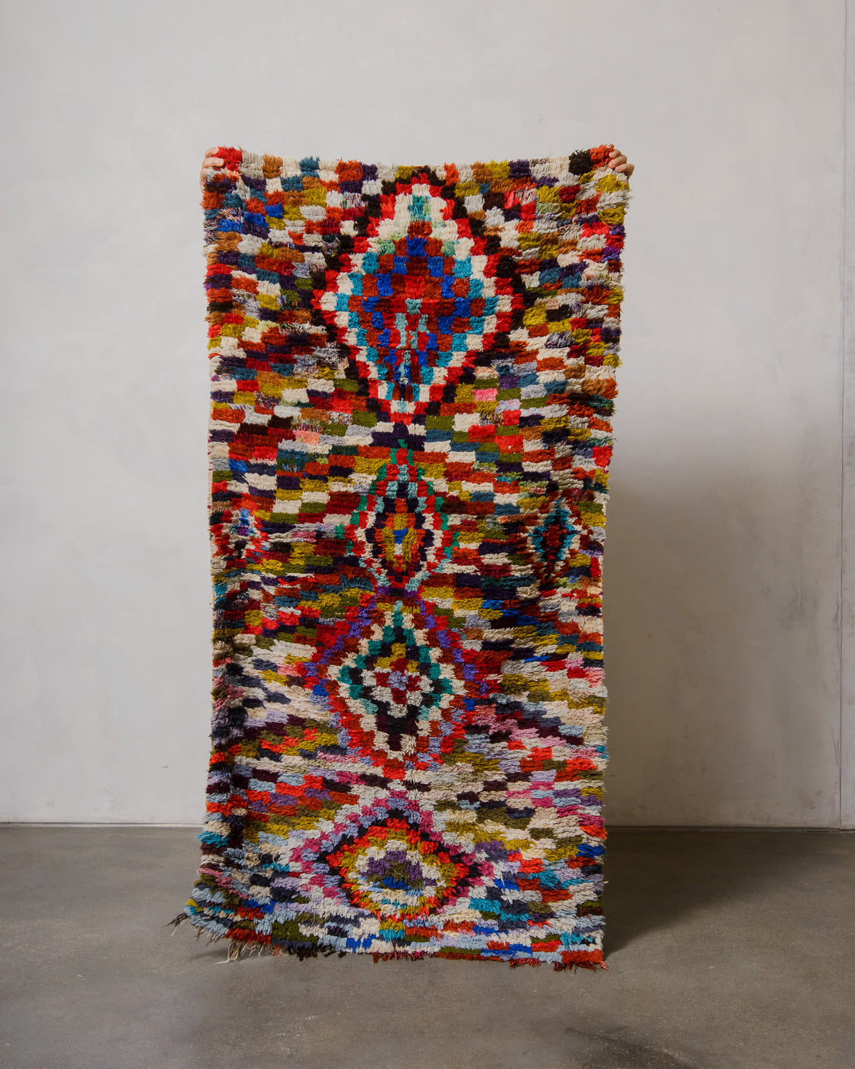 Multicolored geometric patterned rug on a plain background