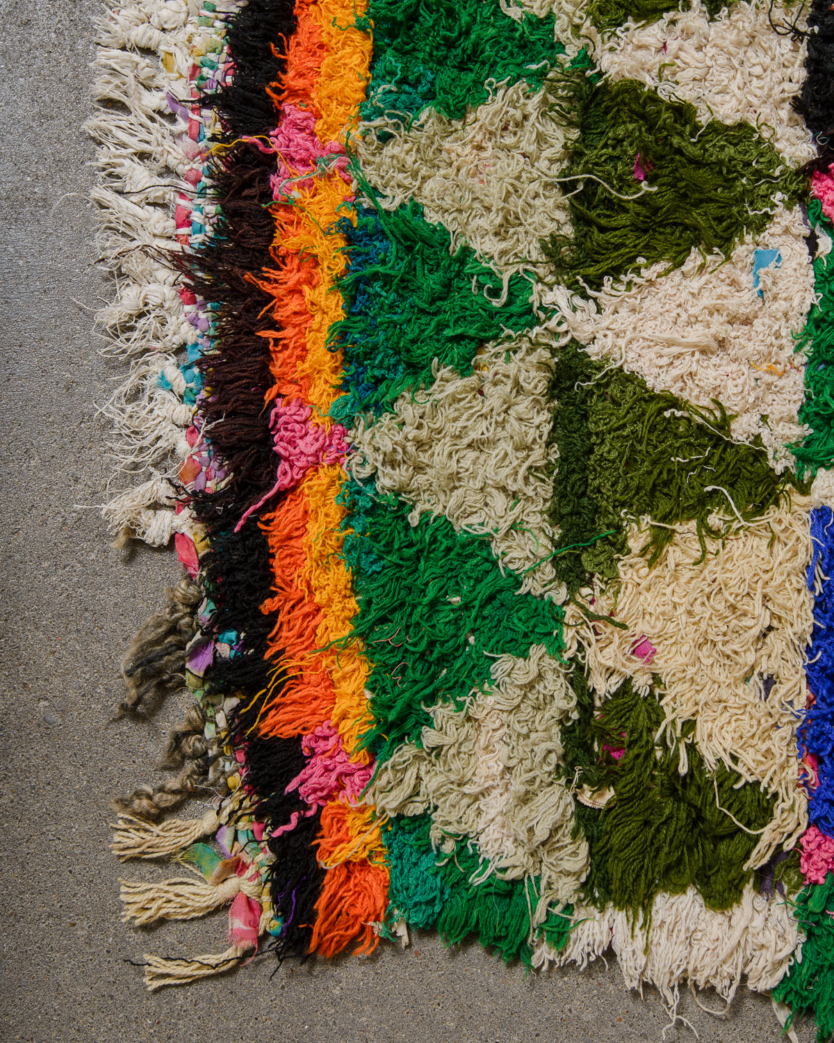 Multicolored textured fabric with fringes on a gray surface