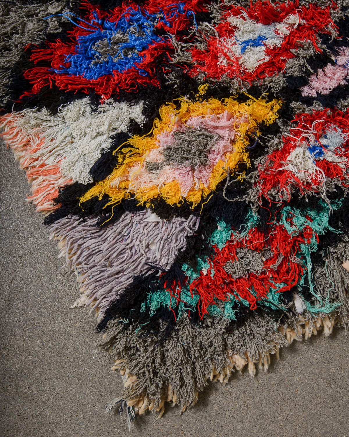 Multicolored textured fabric with fringe on a gray background