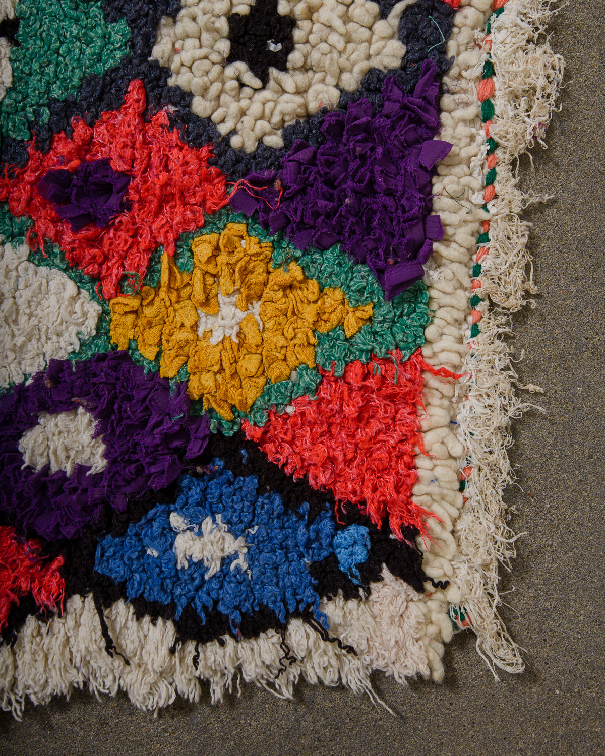 Colourful textured rug with a floral pattern on a dark surface