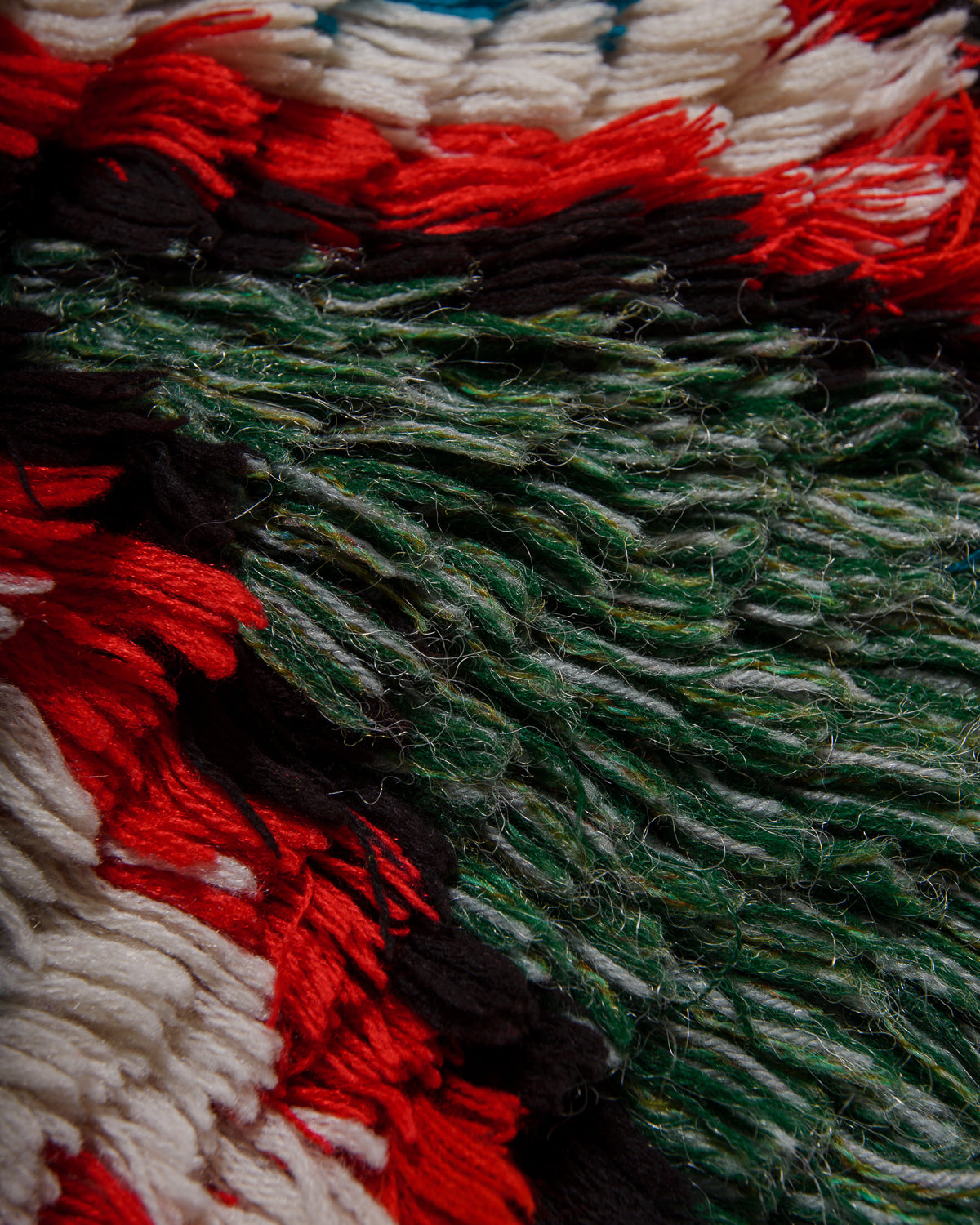 Close-up of textured fabric with red, green, and white colours.