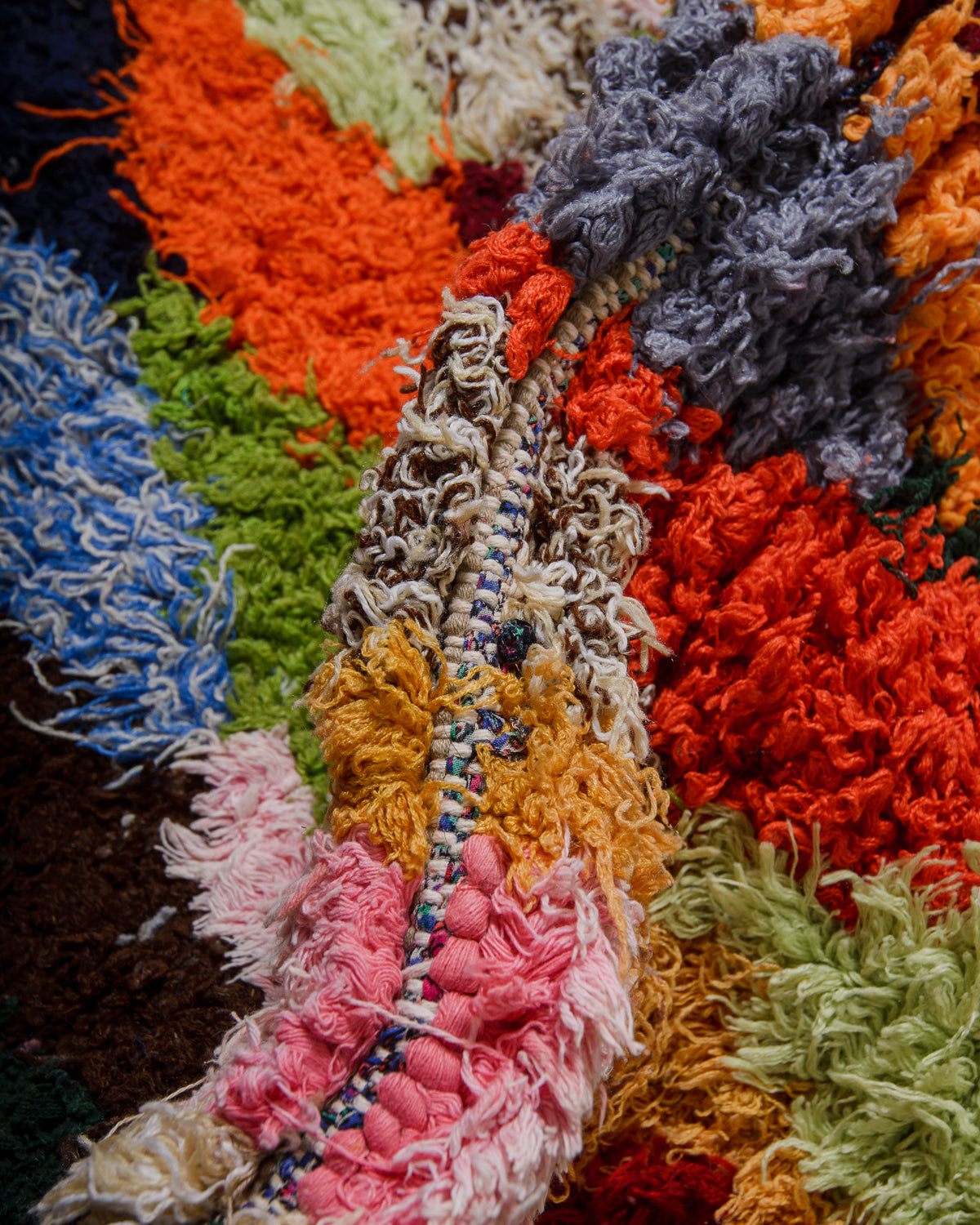 Close-up of a colourful textured fabric with various colors including orange, red, blue, green, and pink.