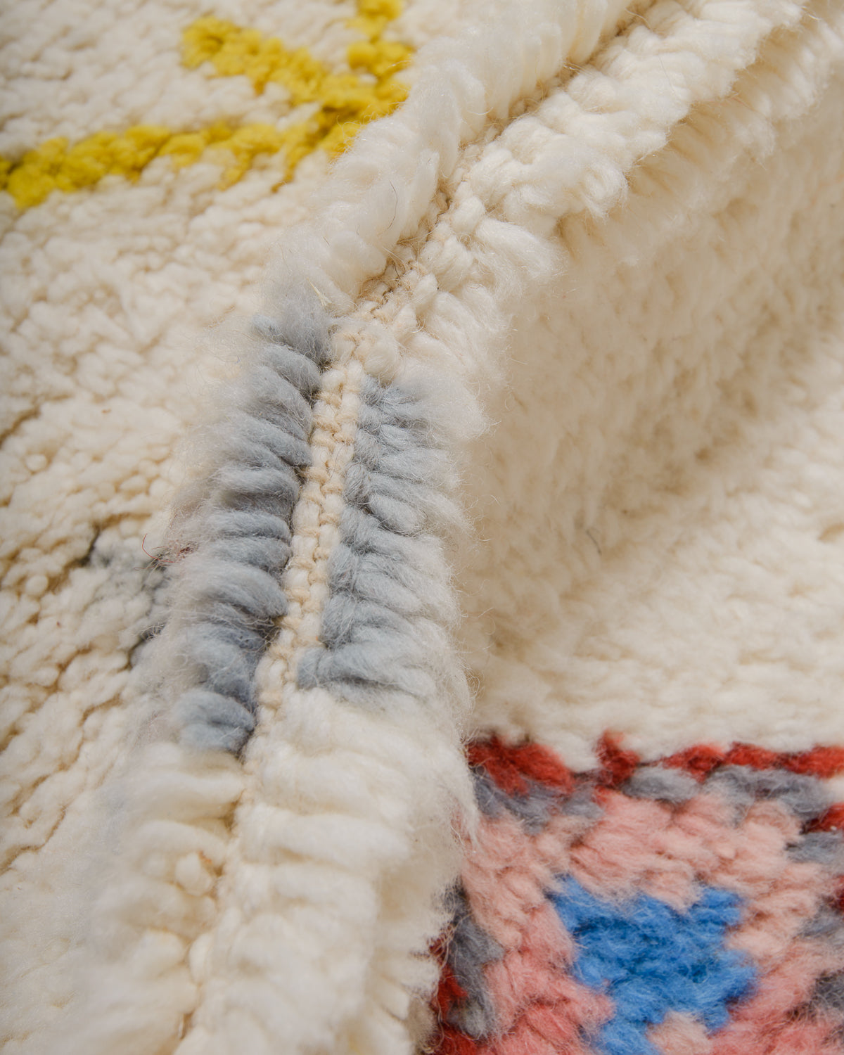 Detail of wool berber rug showing depth of pile and different coloured wool used. 