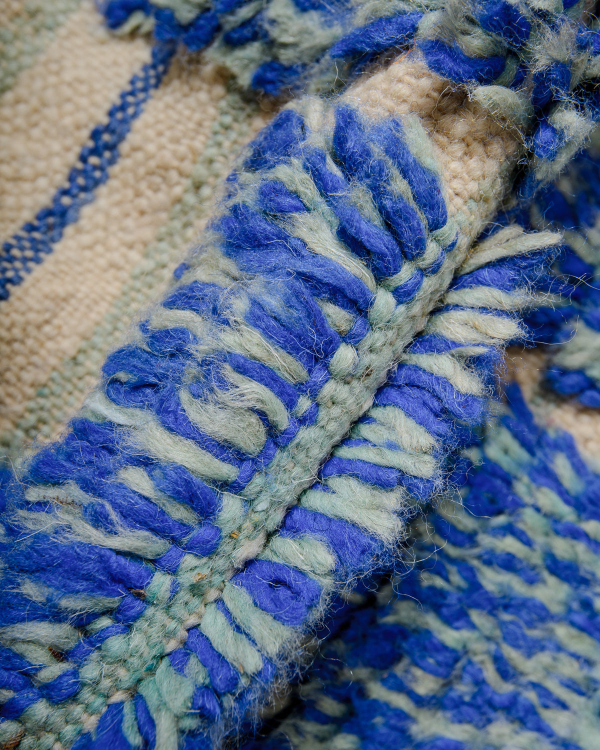 Detail of blue and turquoise berber rug showing the density of the knots and the length of the wool.