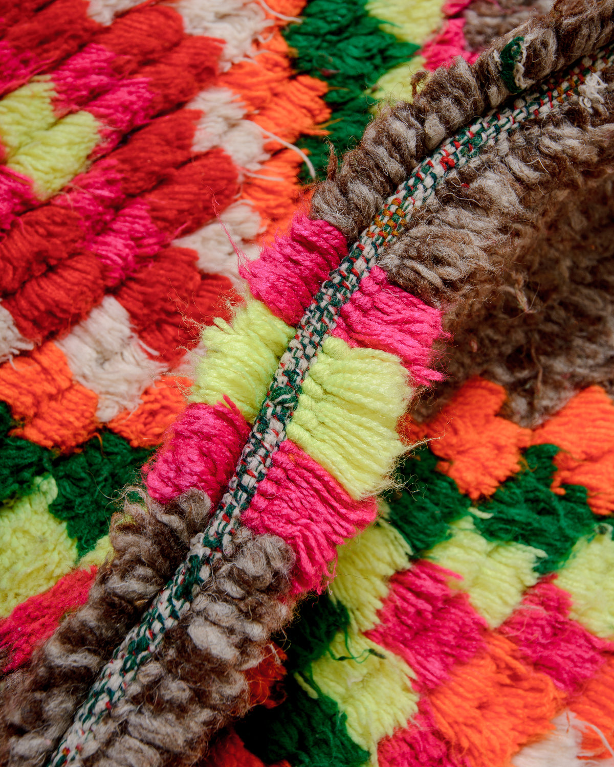 Detail of vintage berber rug showing the density of knots, made of brown wool and colourful cotton.