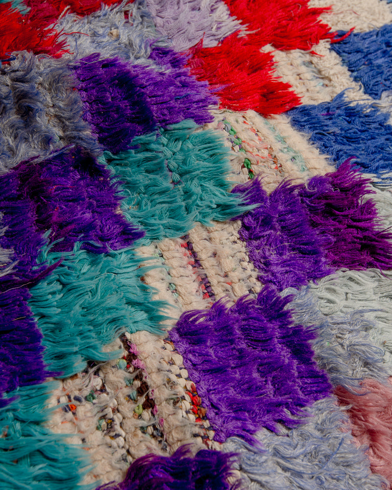 close up of surface of boucherouite rug with many coloured squares.