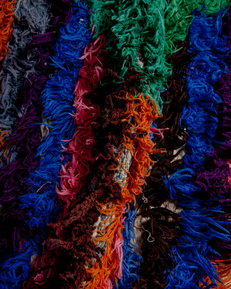 Close up of boucherouite rug with colourful cotton and fabric remnants.